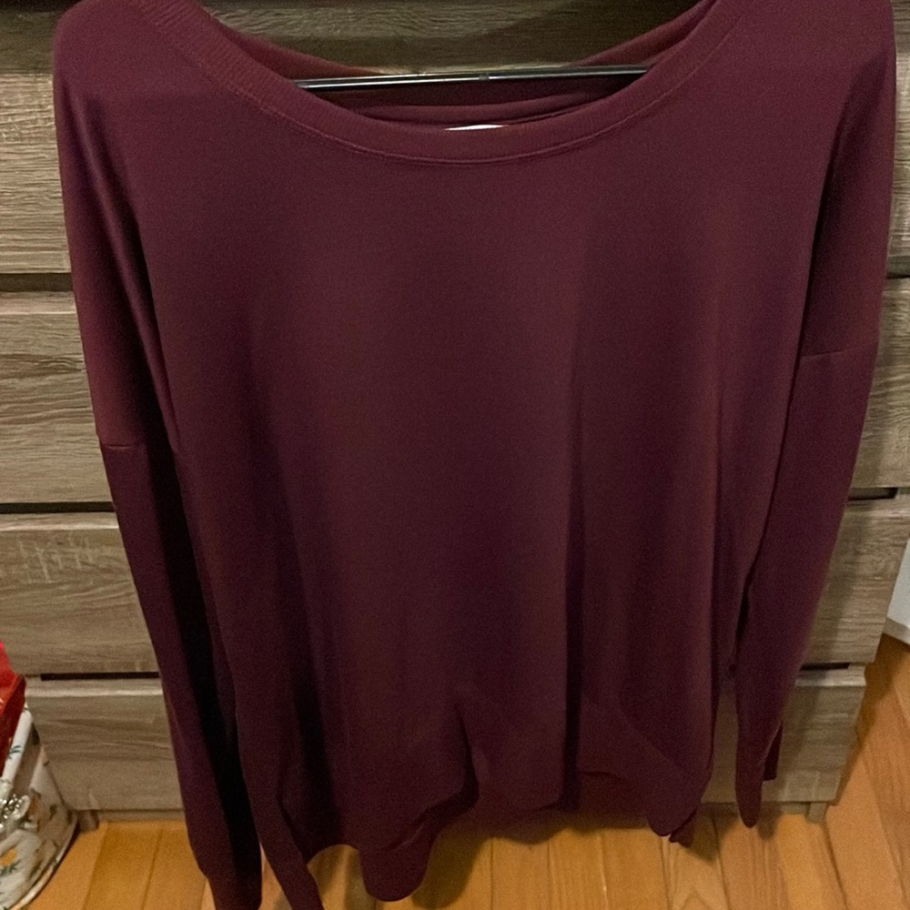 Long sleeve shirt, thin crew neck, very roomy. It’s plum to a deep maroon.